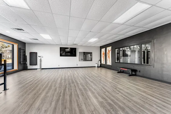 a view of an empty room with wooden floor and windows