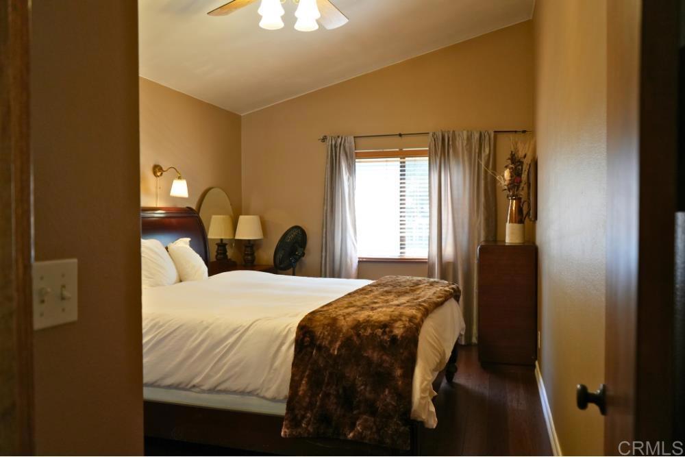 7192 Sandy Creek Road Julian, CA 92036 - Photo 12 of 64 a bedroom with a bed and a chandelier