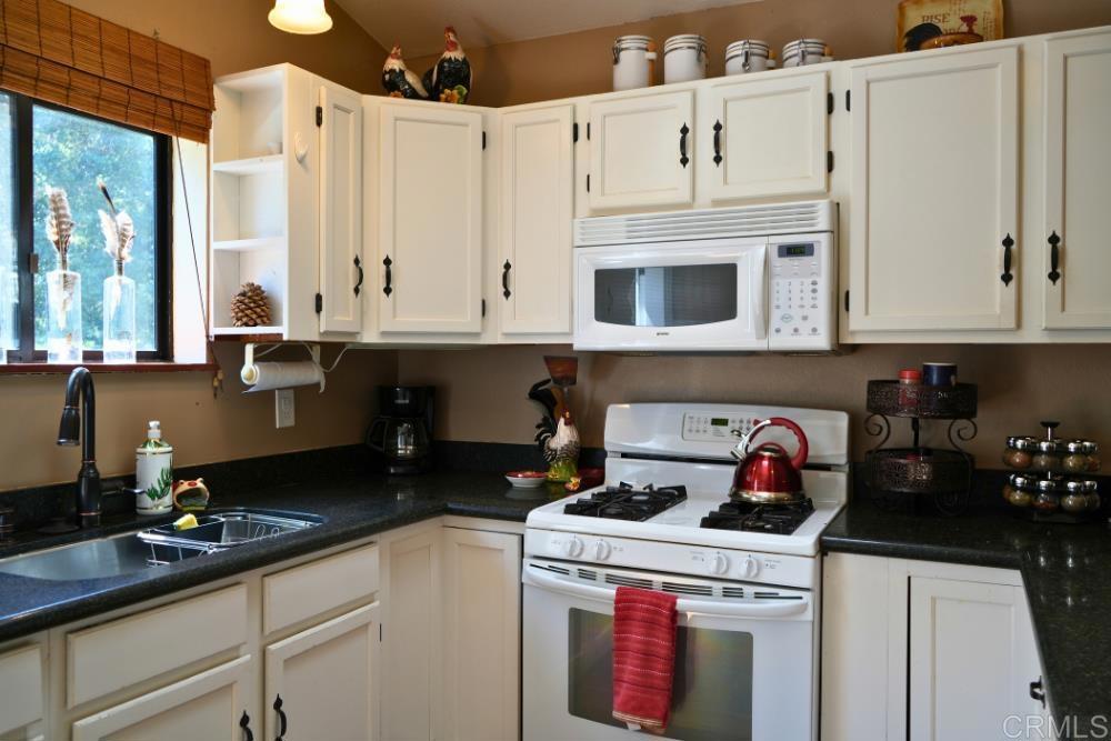 7192 Sandy Creek Road Julian, CA 92036 - Photo 2 of 64 a kitchen with granite countertop a sink a stove and cabinets