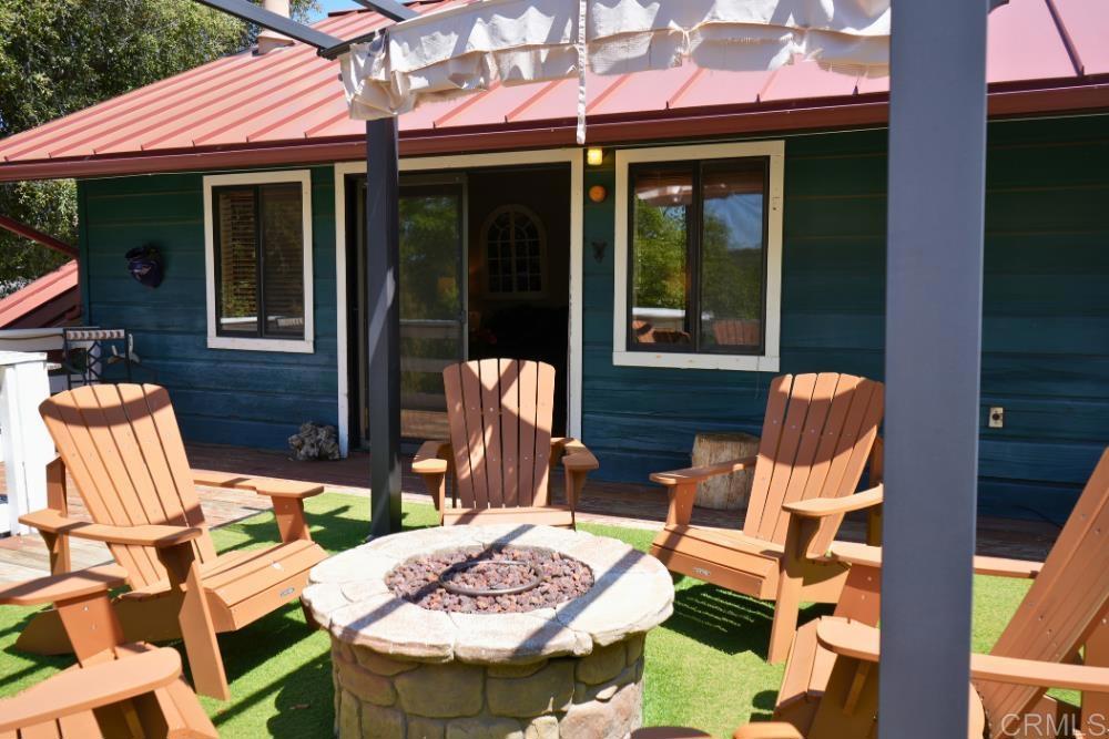 7192 Sandy Creek Road Julian, CA 92036 - Photo 23 of 64 a view of a patio with a dining table and chairs under an umbrella