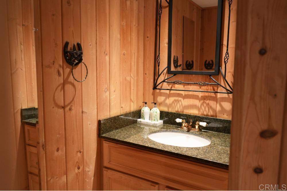 7192 Sandy Creek Road Julian, CA 92036 - Photo 27 of 64 a bathroom with a granite countertop sink and a mirror