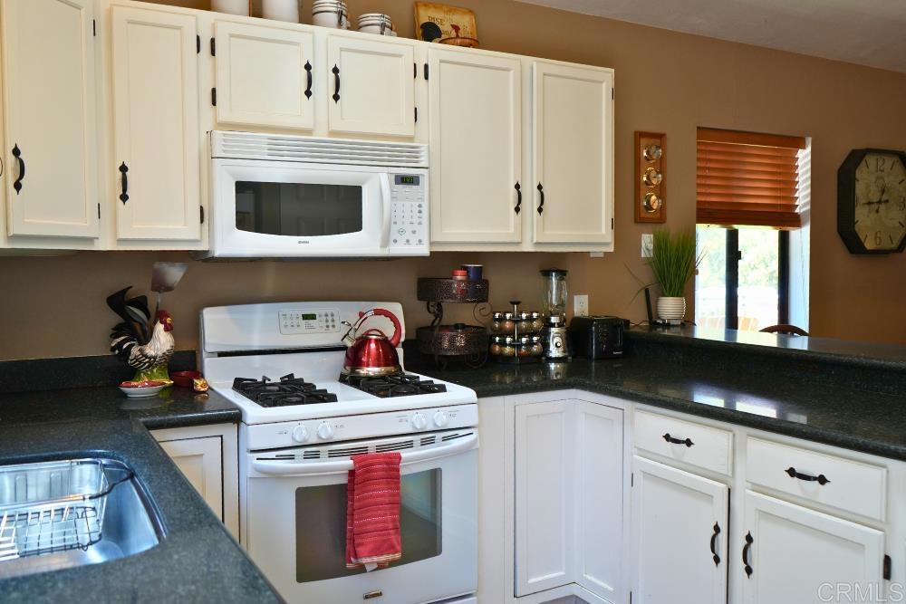 7192 Sandy Creek Road Julian, CA 92036 - Photo 3 of 64 a kitchen with a stove and a white cabinets