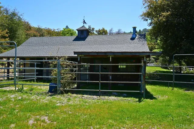 a view of a house with a lush green forest