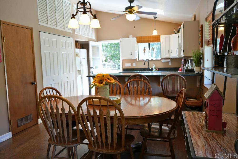 7192 Sandy Creek Road Julian, CA 92036 - Photo 10 of 64 a dining room with furniture a chandelier and wooden floor
