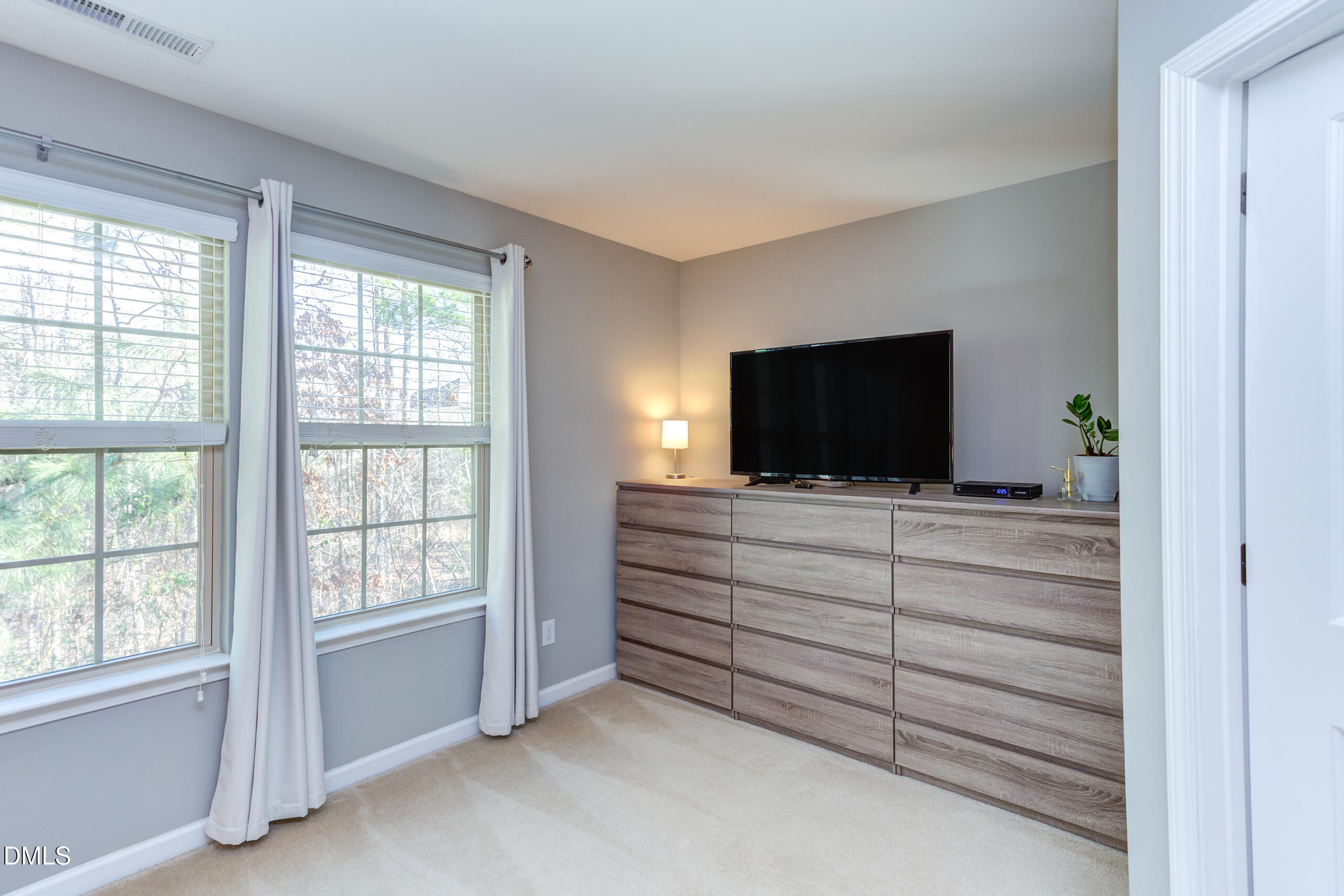1434 Chatuga Way Wake Forest, NC 27587 - Photo 18 of 29 a room with flat screen tv cabinets and a bed
