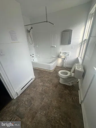 a bathroom with a sink a toilet and a mirror