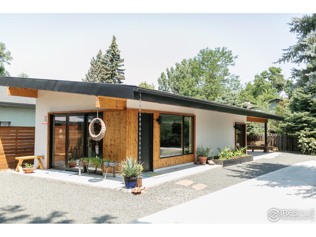 2600 West Prospect Road Fort Collins, CO 80526 - Photo 35 of 40 a view of a brick house with potted plants and a large tree