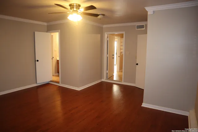 a view of an empty room with wooden floor