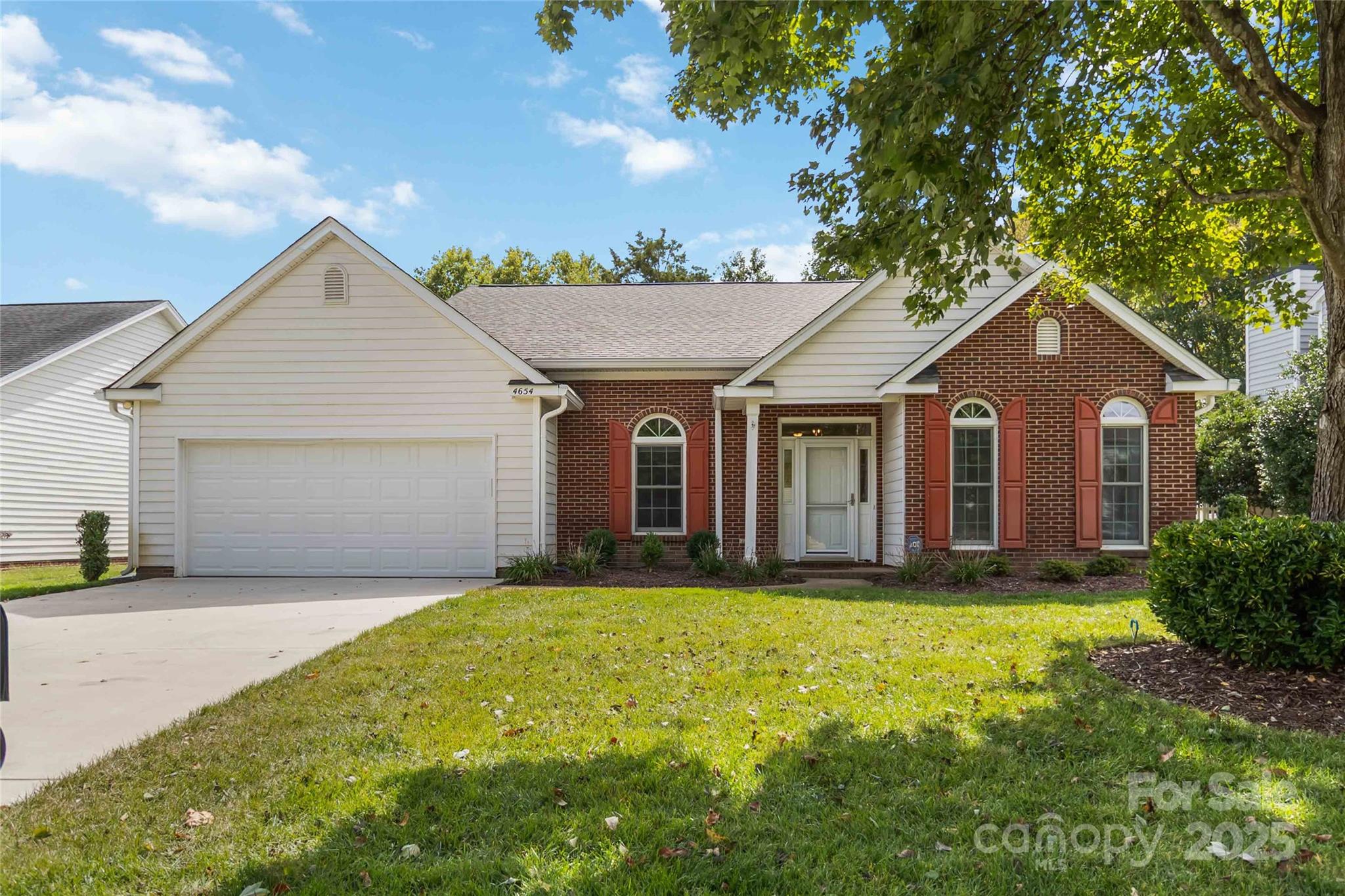 a view of a yard in front of a house with large trees