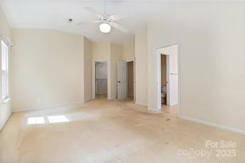 an empty room with a ceiling fan and a window