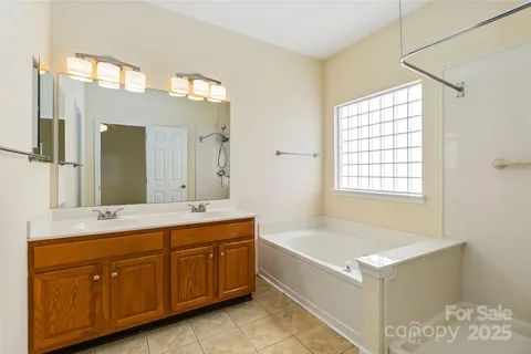 a spacious bathroom with a tub sink and mirror