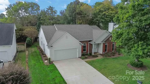 a aerial view of a house next to a big yard and large trees