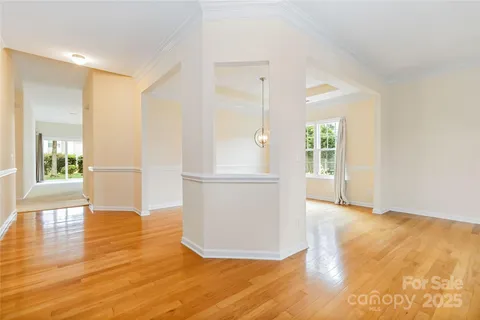a view of a hallway with wooden floor and a living room
