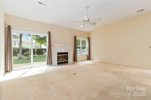 a view of an empty room with a fireplace and a window
