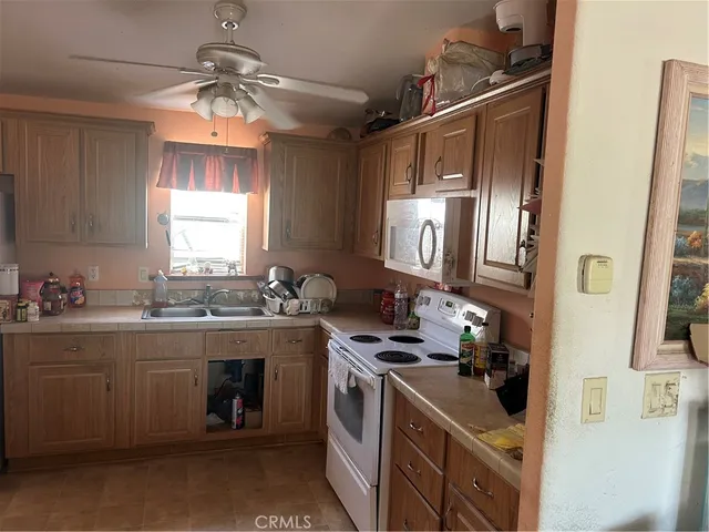 a kitchen with refrigerator and chairs