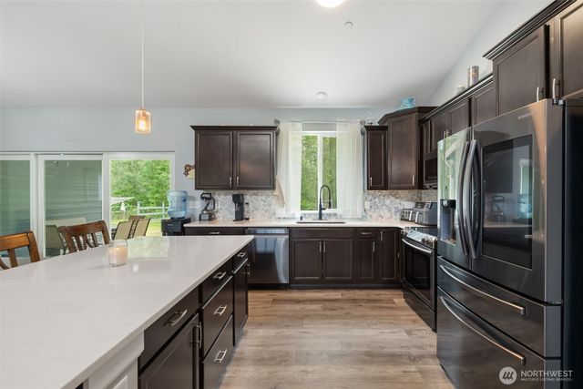 a kitchen with stainless steel appliances granite countertop a sink refrigerator and cabinets