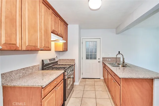 a kitchen with granite countertop stainless steel appliances white cabinets and a stove