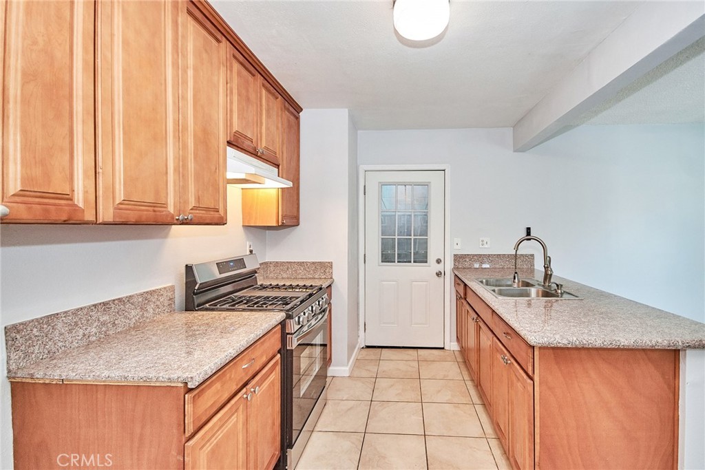 9510 1/2 Beverly Street Bellflower, CA 90706 - Photo 17 of 30 a kitchen with stainless steel appliances granite countertop a sink stove and cabinets