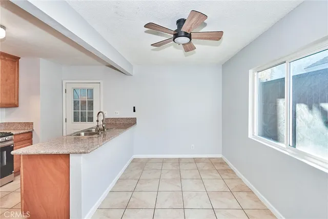 an empty room with windows and ceiling fan