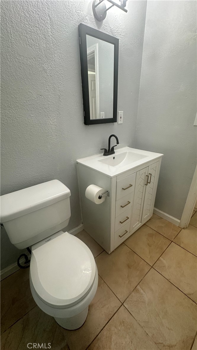 9510 1/2 Beverly Street Bellflower, CA 90706 - Photo 28 of 30 a bathroom with a toilet sink and mirror