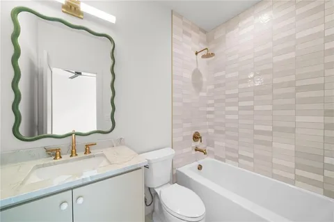 a bathroom with a granite countertop sink a toilet and a bathtub