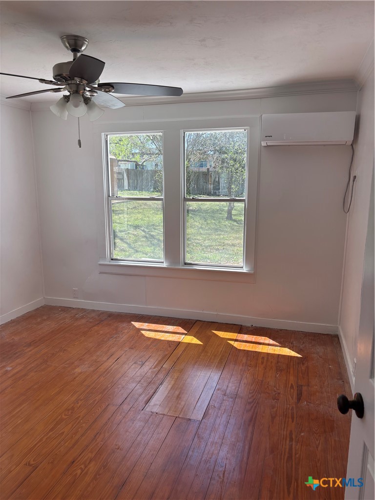 308 Poth Street Yoakum, TX 77995 - Photo 13 of 13 a view of an empty room with wooden floor and a window