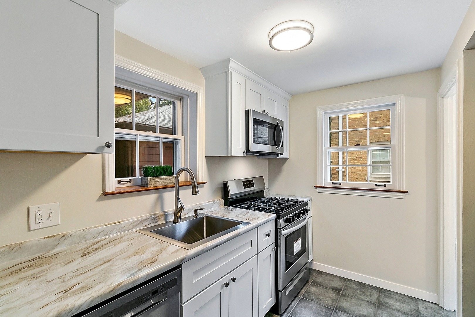 8132 West 26th Street North Riverside, IL 60546 - Photo 4 of 16 a kitchen with stainless steel appliances granite countertop a sink a stove and a microwave