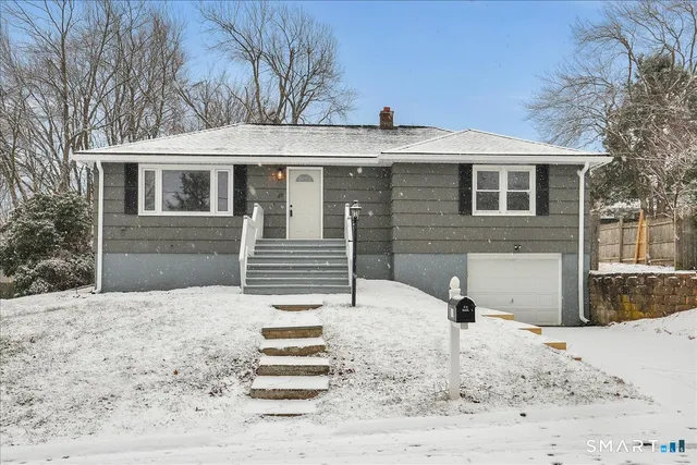 a front view of a house with a yard covered with snow