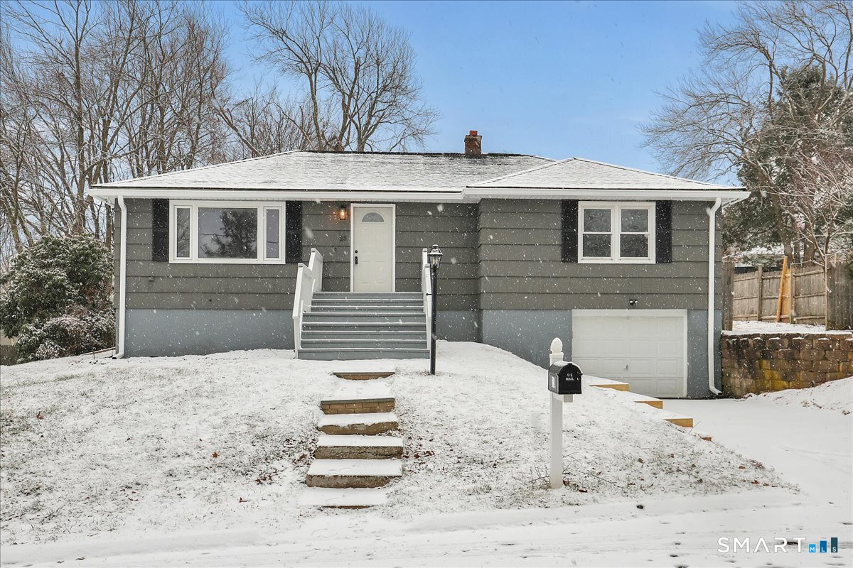 a front view of a house with a yard covered with snow