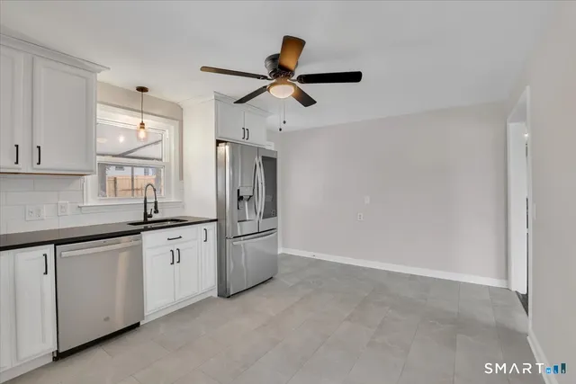 a kitchen with white cabinets and appliances