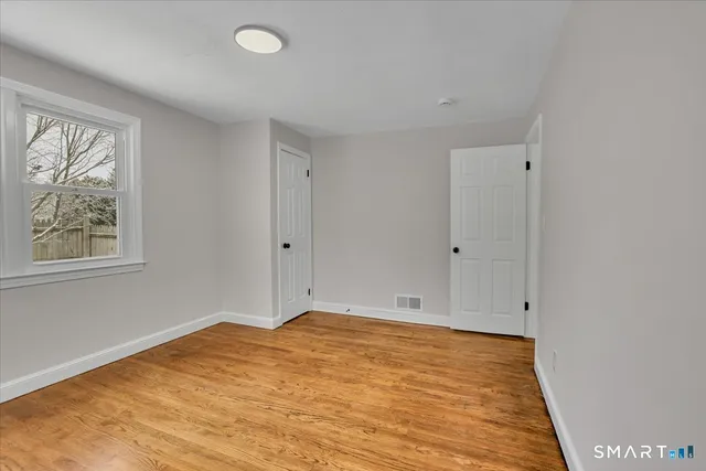 a view of room with window and wooden floor