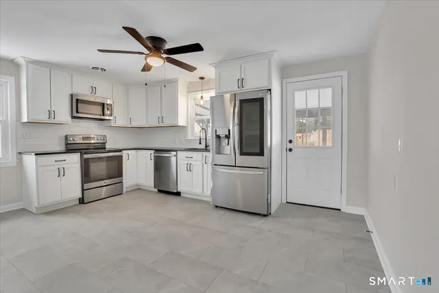 a kitchen with white cabinets and white appliances