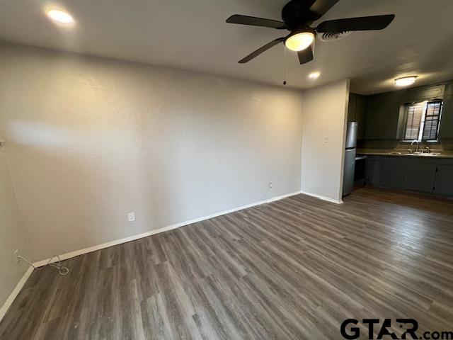 314 South Center Street Longview, TX 75601 - Photo 3 of 8 an empty room with wooden floor and a ceiling fan