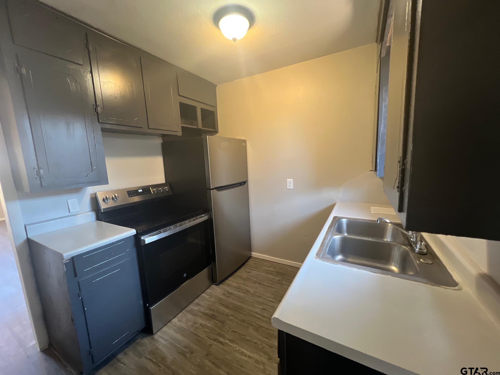 314 South Center Street Longview, TX 75601 - Photo 5 of 8 a kitchen that has a sink and a stove in it