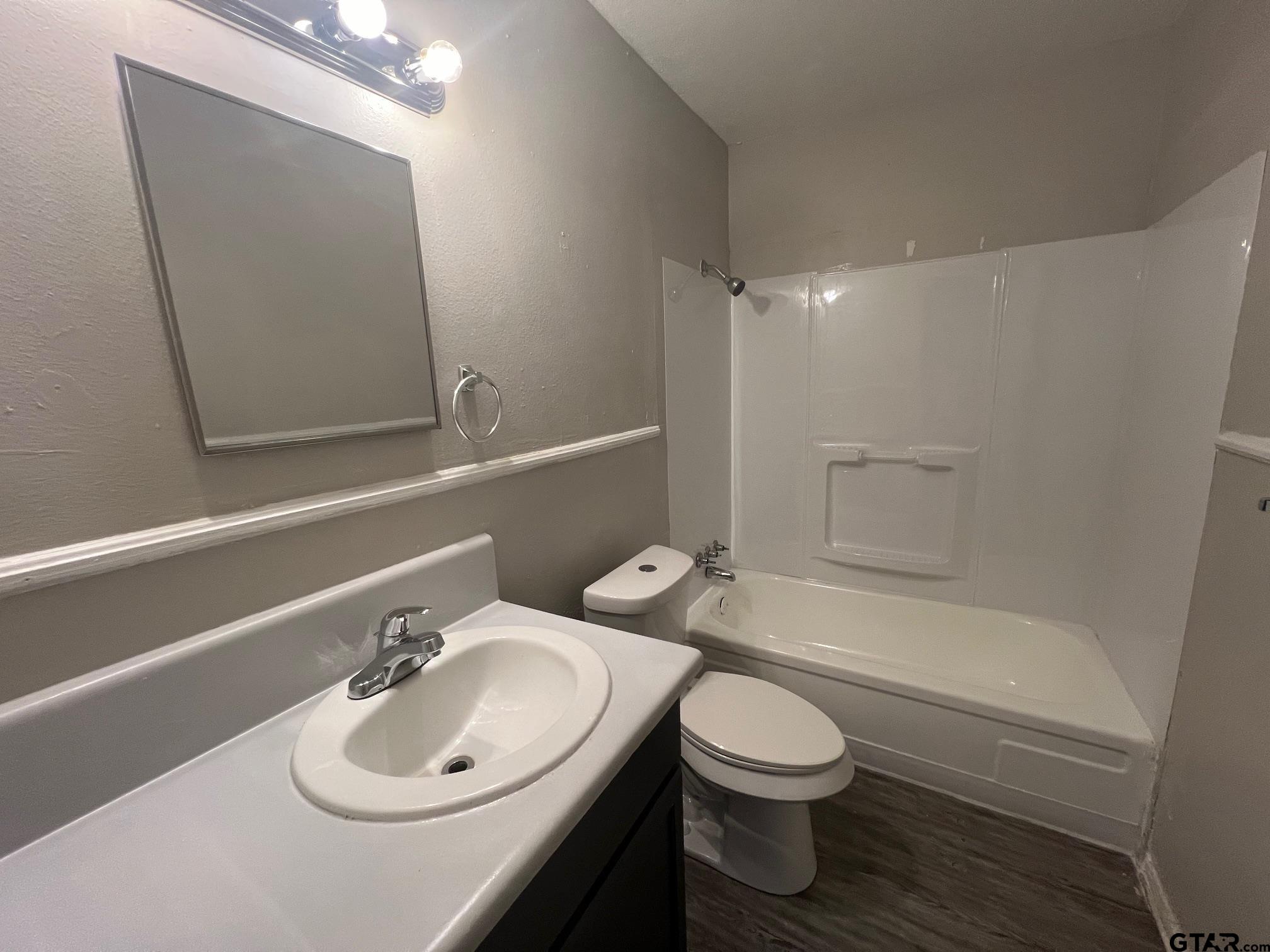 314 South Center Street Longview, TX 75601 - Photo 7 of 8 a bathroom with a sink a toilet and shower