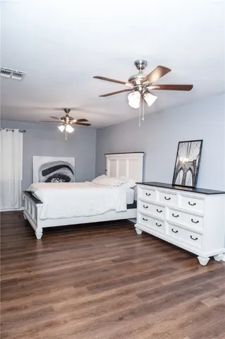 a view of a bedroom with furniture and wooden floor