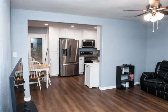 a kitchen with stainless steel appliances a refrigerator and wooden floor