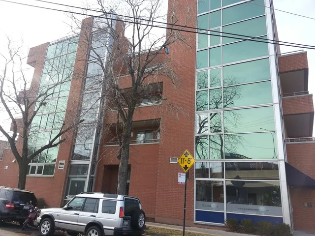 a front view of a building and car parked