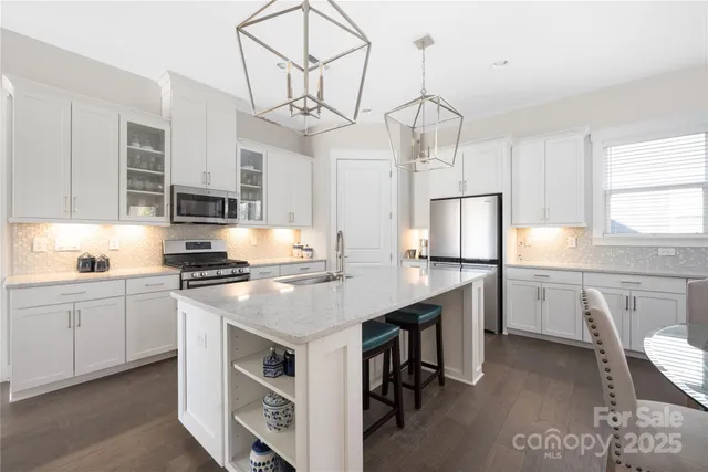 a kitchen with stainless steel appliances kitchen island a sink and a refrigerator