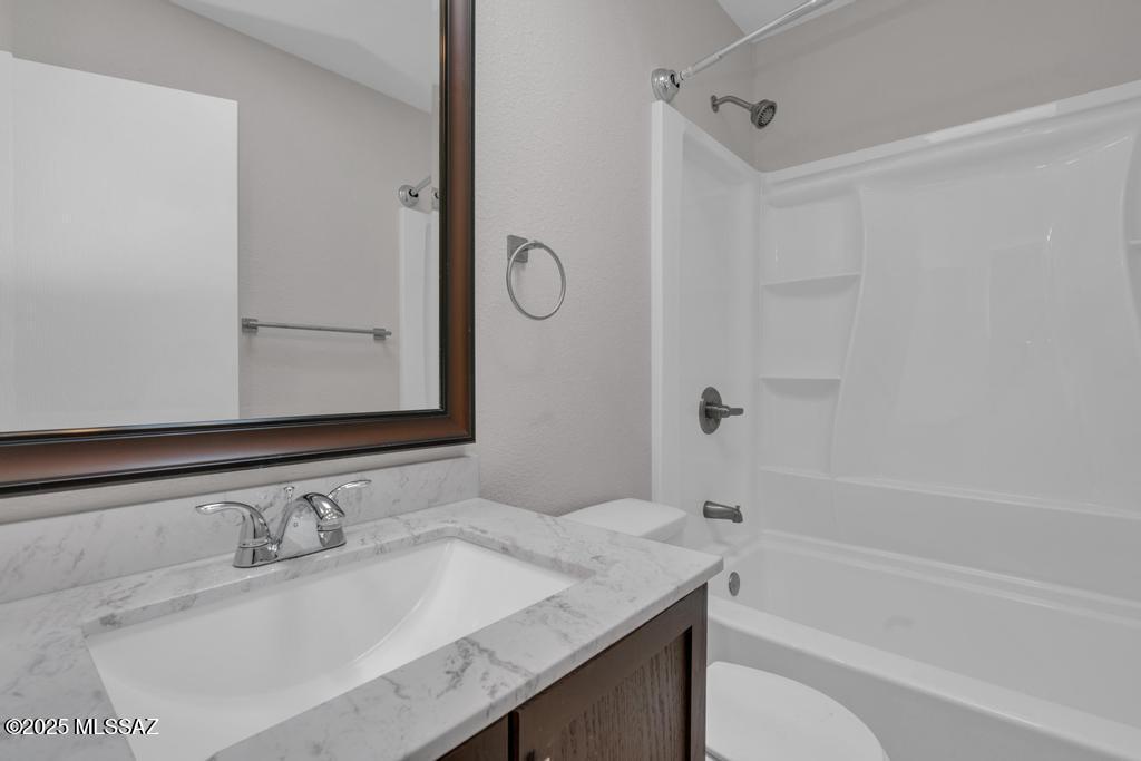 211 West Roger Road, Unit 35 Tucson, AZ 85705 - Photo 15 of 24 a bathroom with a granite countertop sink mirror and a bathtub