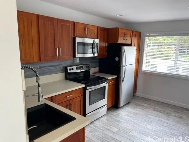 a kitchen with stainless steel appliances granite countertop a stove a refrigerator and a microwave