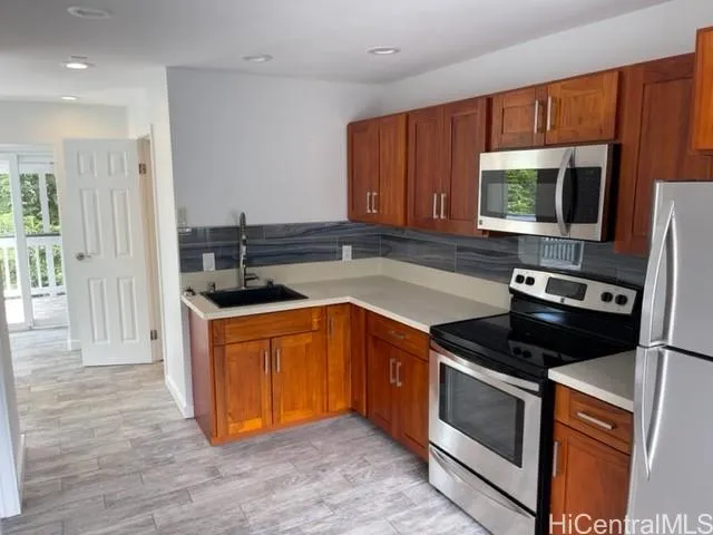 a kitchen with stainless steel appliances granite countertop a stove a sink and a microwave