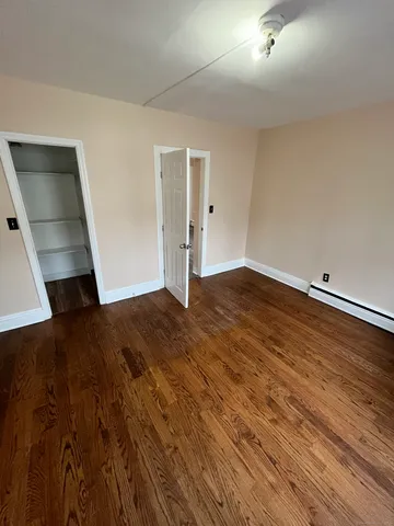 an empty room with wooden floor and entrance