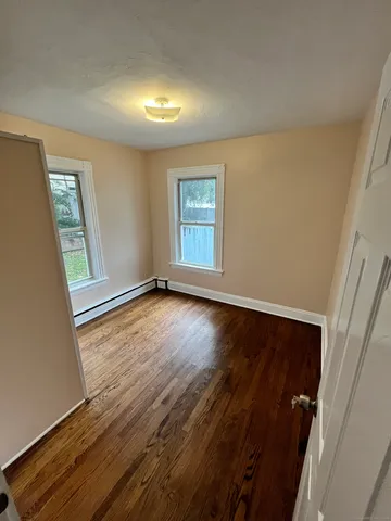 wooden floor in an empty room with a window