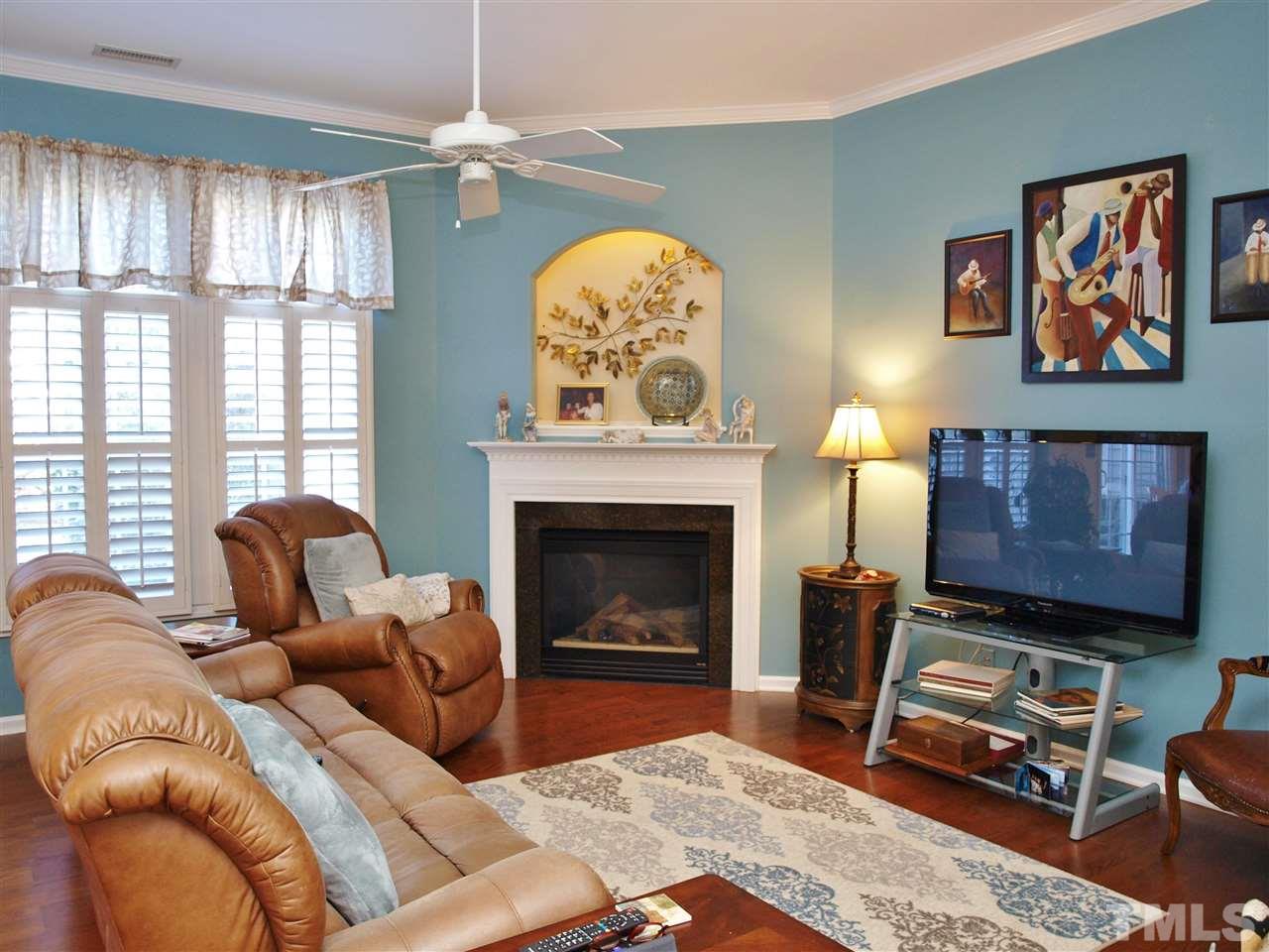 1402 Basinger Court Raleigh, NC 27612 - Photo 2 of 16 a living room with furniture a chandelier and a fireplace