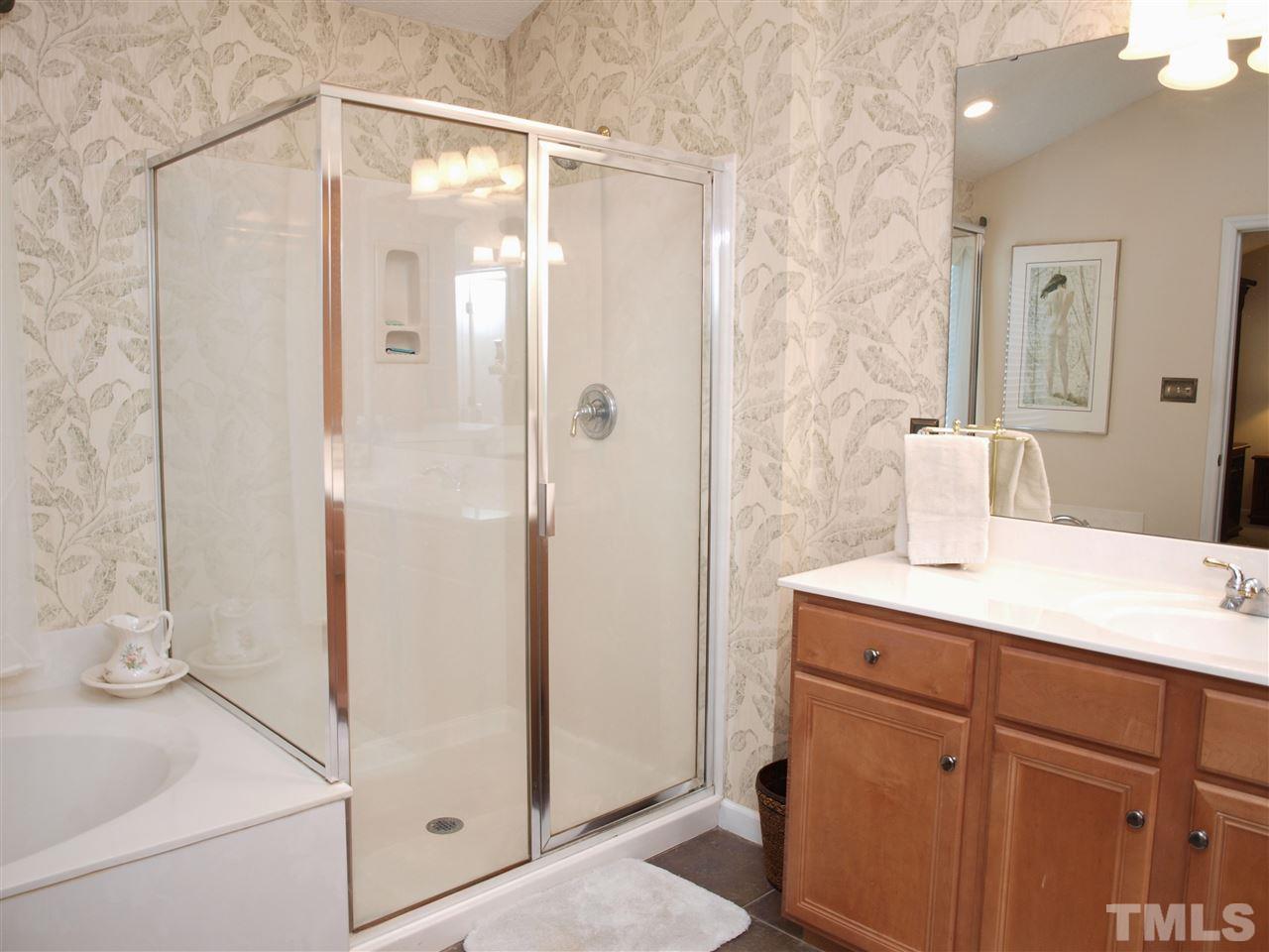 1402 Basinger Court Raleigh, NC 27612 - Photo 12 of 16 a bathroom with a shower sink and mirror