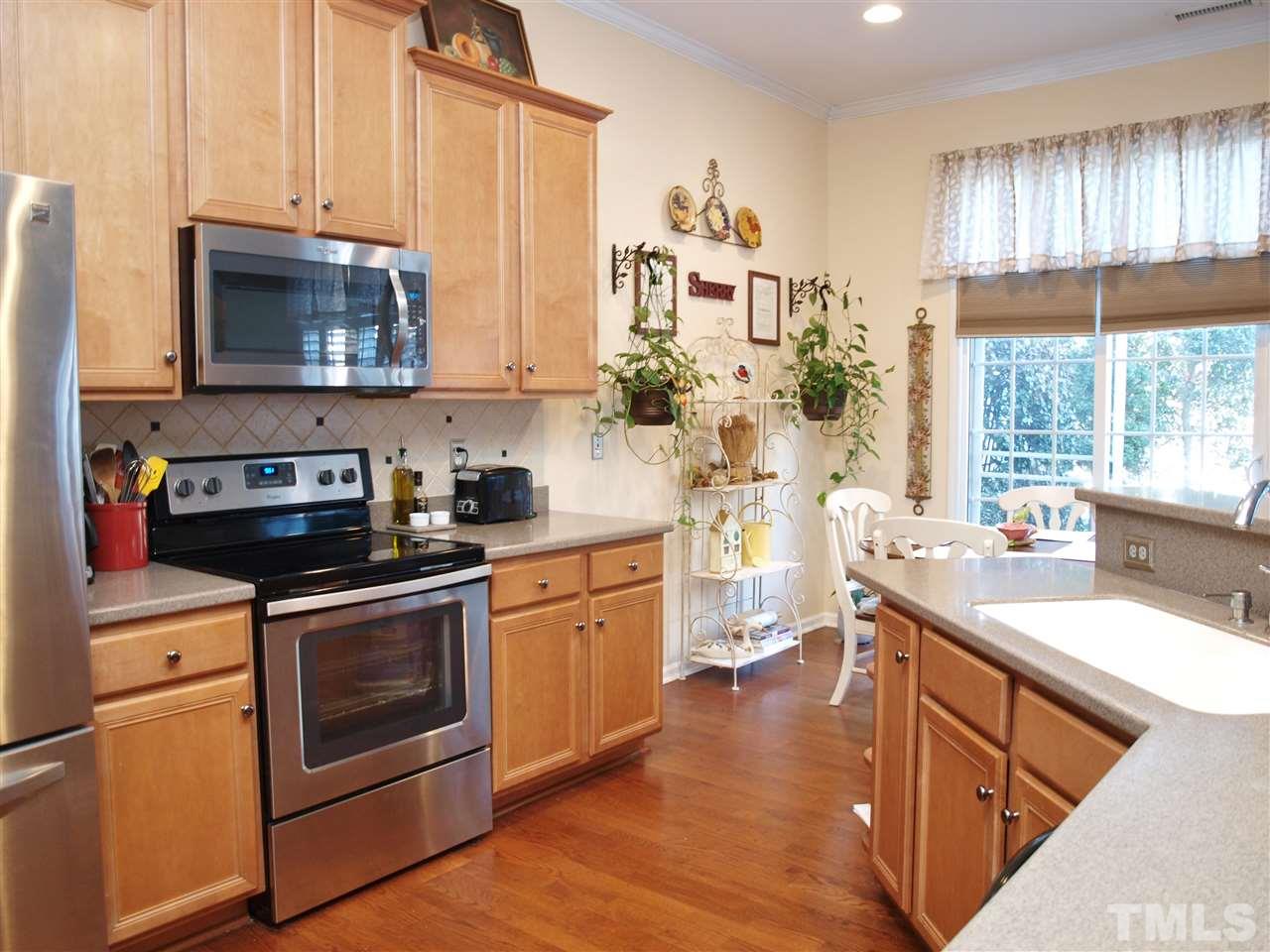 1402 Basinger Court Raleigh, NC 27612 - Photo 5 of 16 a kitchen with stainless steel appliances granite countertop a stove a sink and a microwave