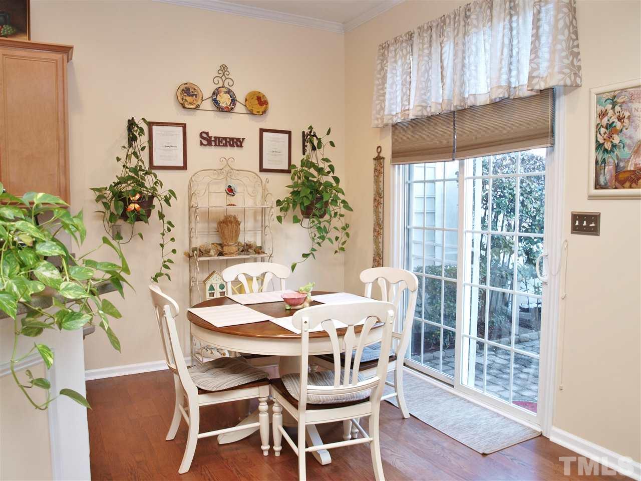 1402 Basinger Court Raleigh, NC 27612 - Photo 7 of 16 a dining room with furniture a window and wooden floor