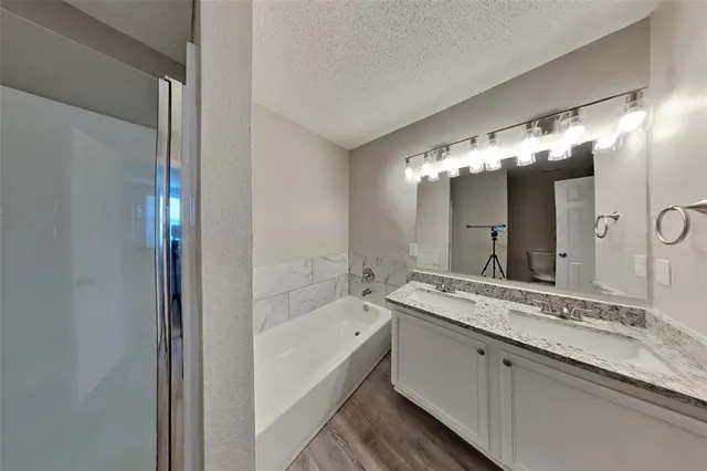 a bathroom with a granite countertop sink double vanity and a mirror