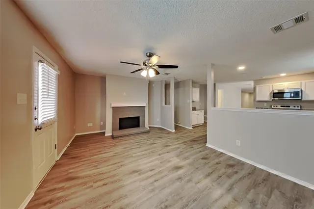 a view of an empty room with a fireplace and a window